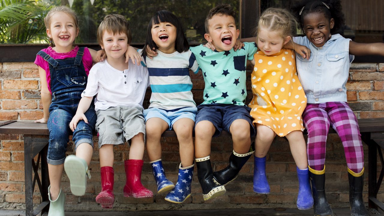 A group of children sitting on top of a bench.